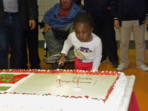 Bambina taglia la torta per il compleanno della UILDM