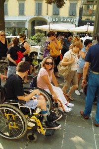 Questa è l’immagine scelta per illustrare la copertina del “Secondo Manifesto sui diritti delle donne e delle ragazze con disabilità nell’Unione Europea”. La donna con disabilità motoria ritratta al centro è Santina Pertesana, campionessa di tiro con l’arco. La fotografia è stata scattata da Annalisa Benedetti, il 9 luglio 2010, a Bergamo, in occasione di una manifestazione contro i tagli al Fondo nazionale per la non autosufficienza.